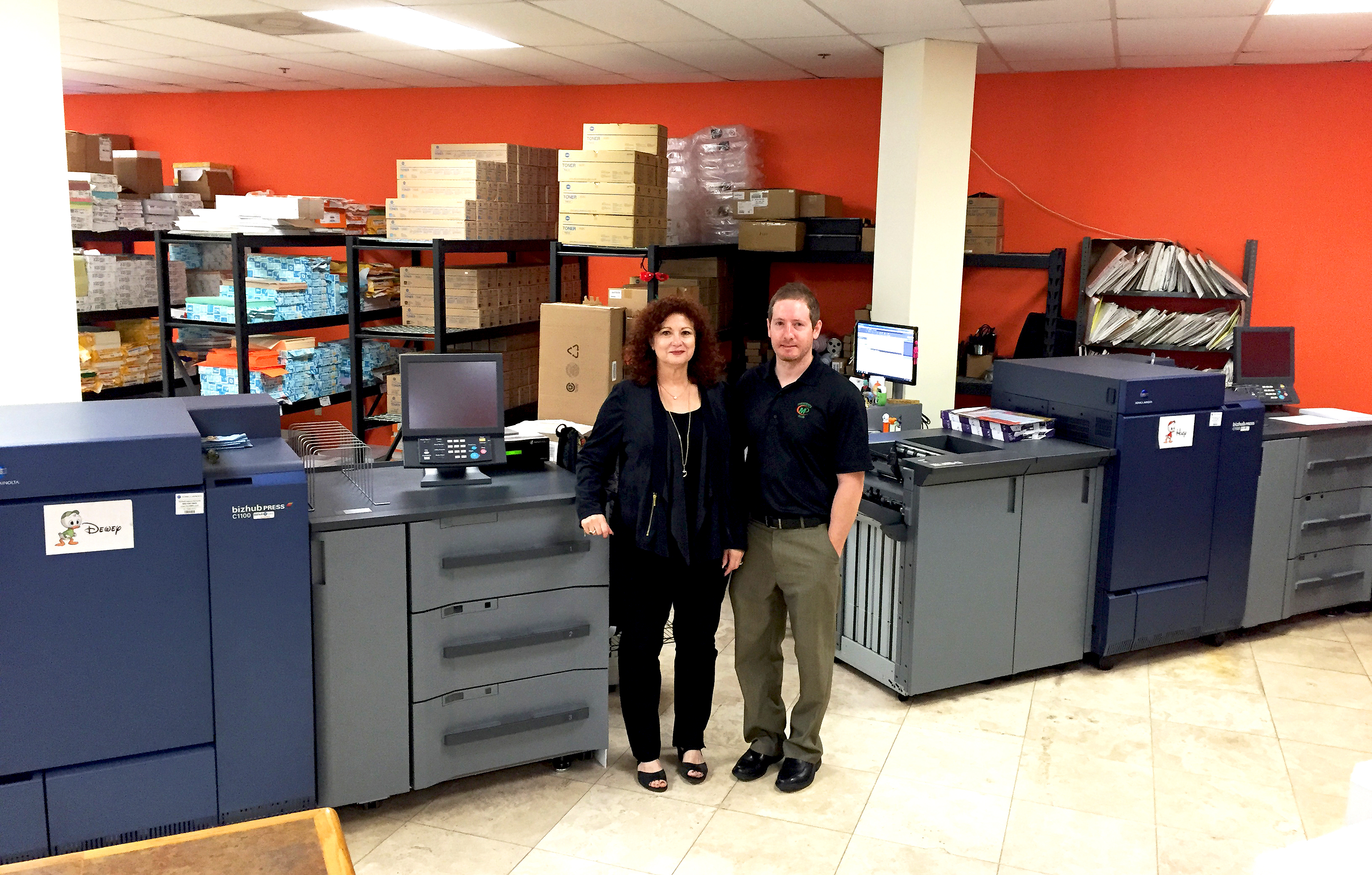 Minuteman Press franchise owner Matthew Perry (right) and his mother Gail alongside two Konica Minolta bizhub PRESS® 1100s.