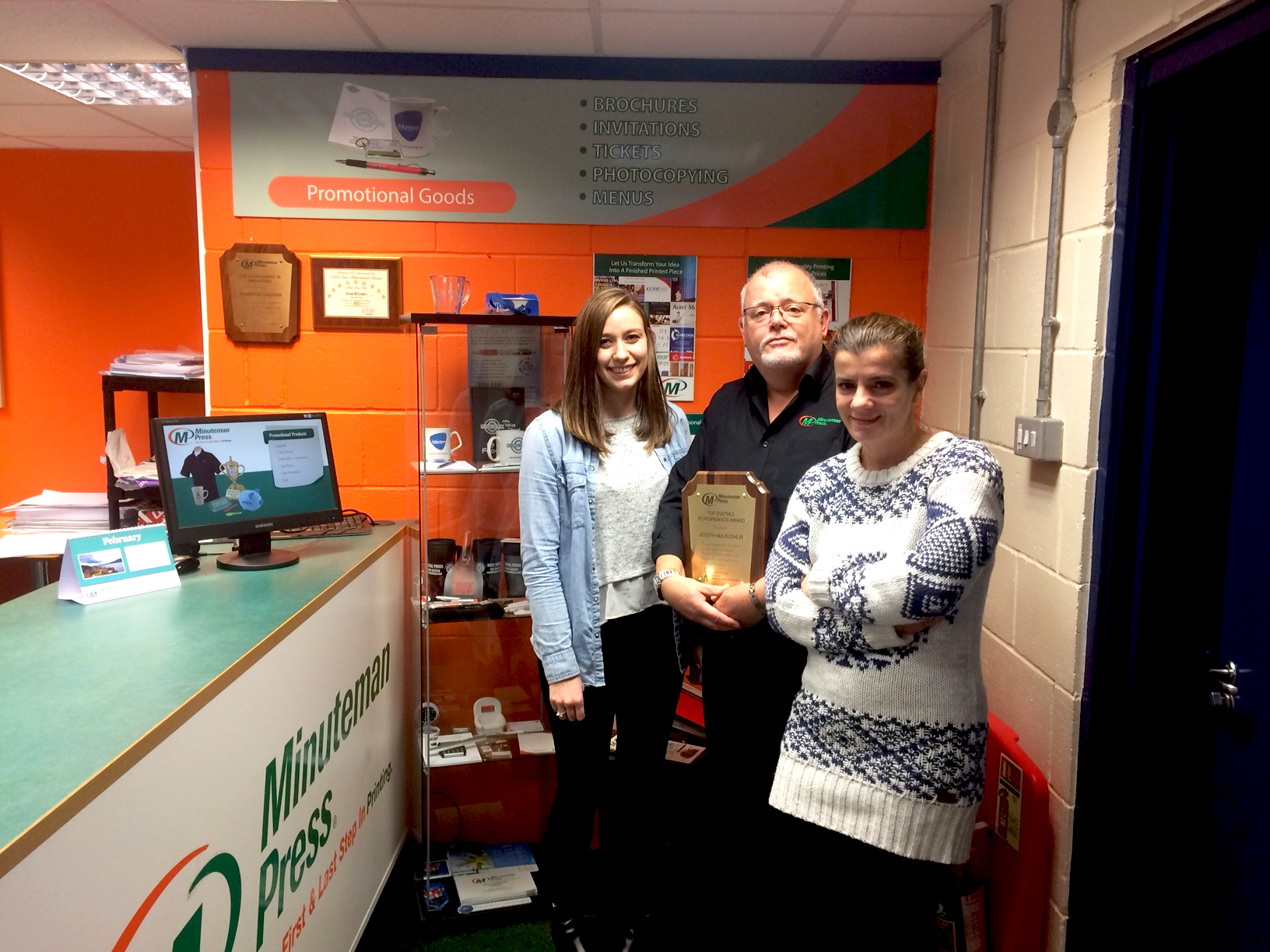 Minuteman Press franchise owner Joe McLaughlin (middle) along with his wife Florina (right) and graphic designer Samantha (left)