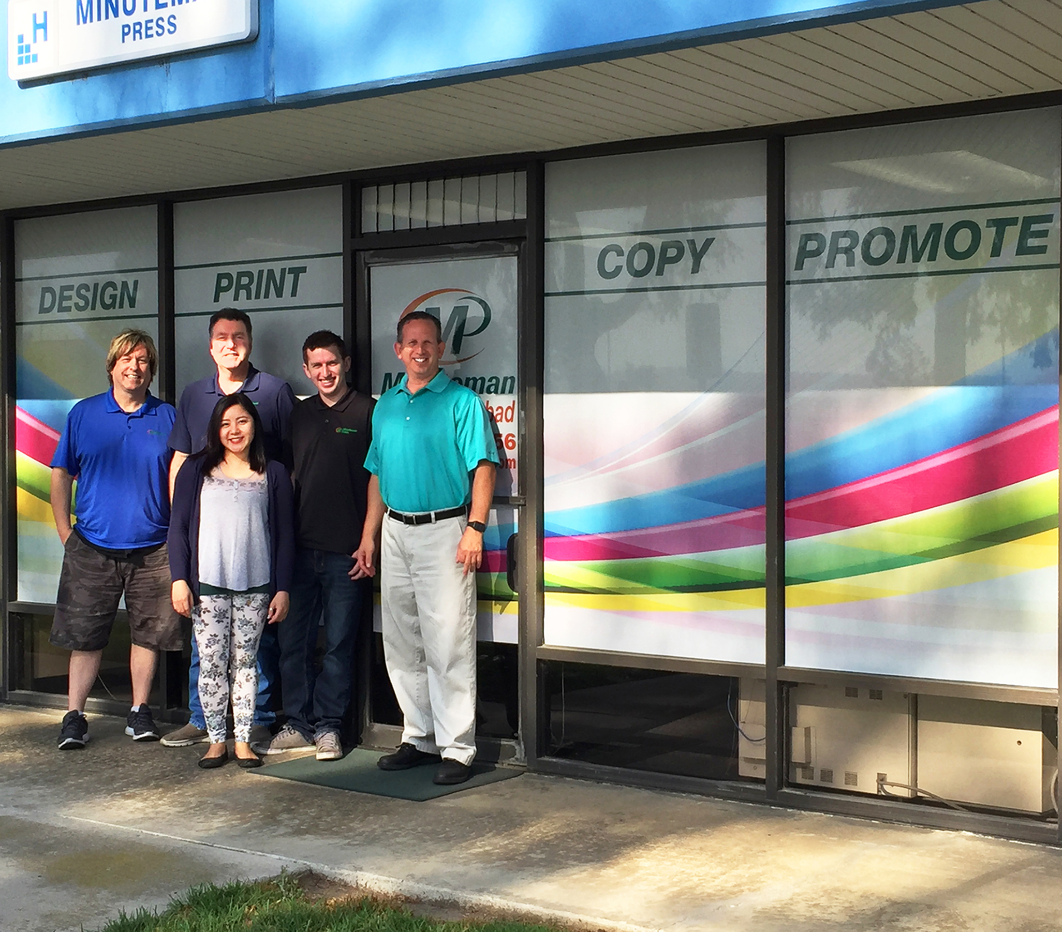 Minuteman Press printing franchise staff in Carlsbad, CA - pictured from left to right: Graphic Design Manager Ron Jones, Production Manager Bill Hawk, Customer Service Manager Karina Revita, Production Specialist Shane Sirota, and Franchise Owner Jeff Sirota.